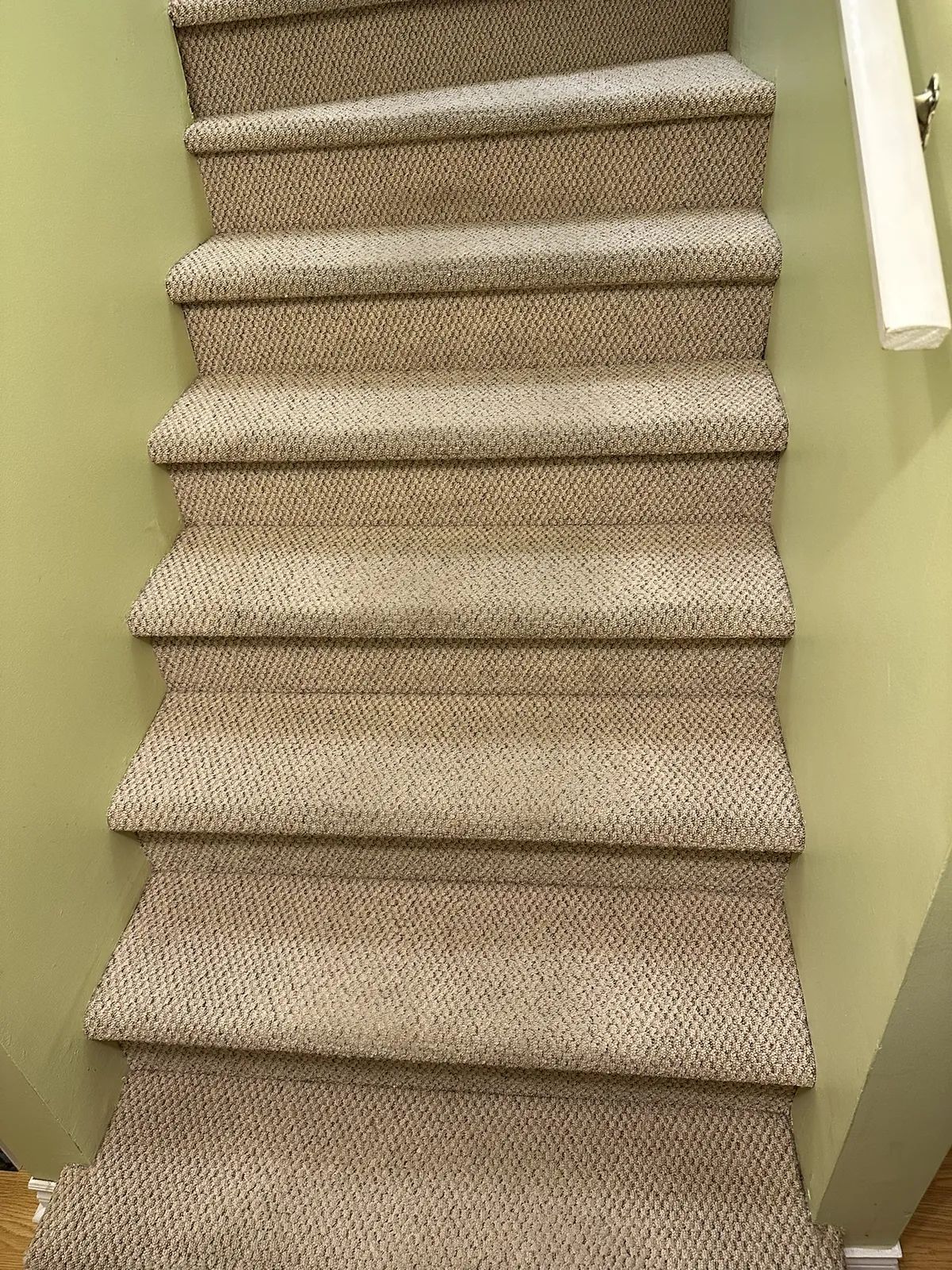 Finished carpeted staircase with tight edges against painted walls